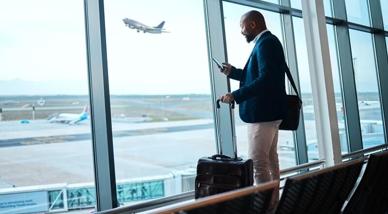 man with phone, airport window and plane taking off, checking flight schedule terminal for business trip